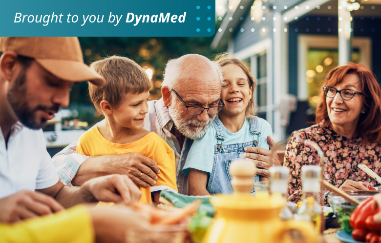 Family gathering together having a meal outside at a table