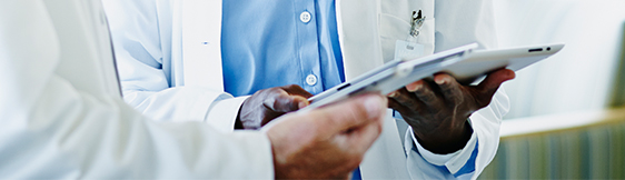 Close up of doctor showing patient someone on tablet