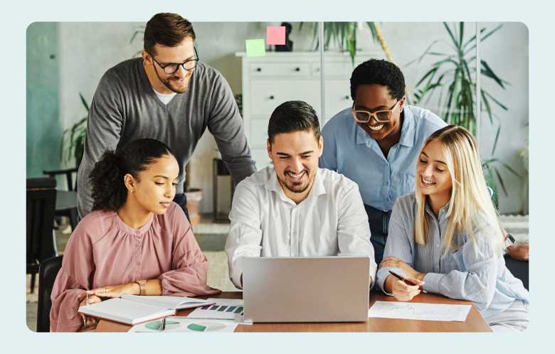 business researchers gathered around a laptop