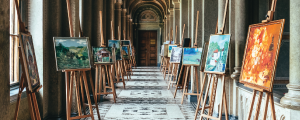 image showing canvases and paintings lining an old hallway