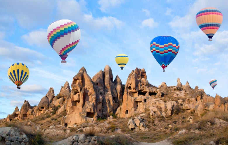 image of hot air balloons in front of rocky steep mountains