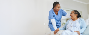 A nurse assisting a patient in a hospital bed