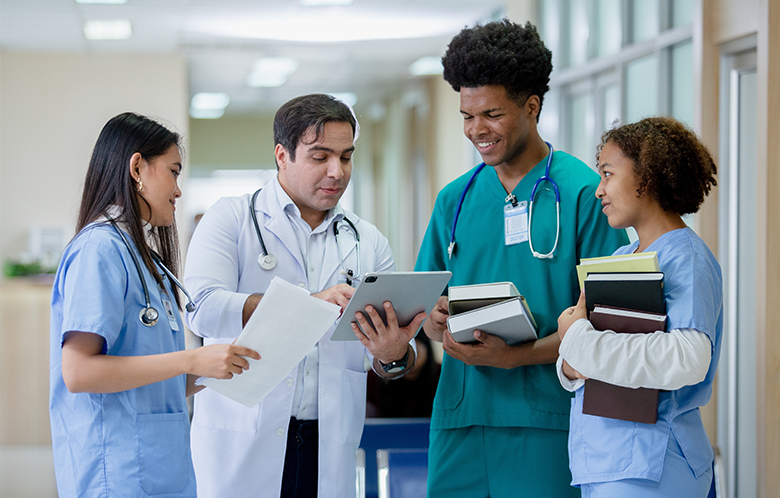 four medical residents researching on tablet device