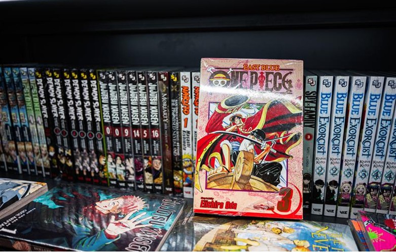 A shelf full of graphic novels lined up with spines facing out.