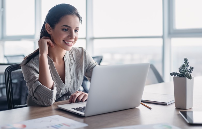 Woman smiling down at a laptop screen