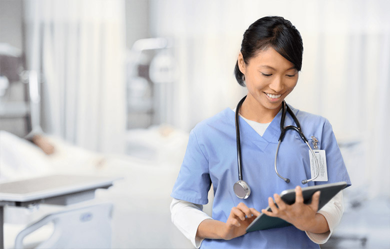 smiling female nurse using ipad