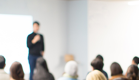 Slightly blurred photo of an adult instructor training other in a classroom