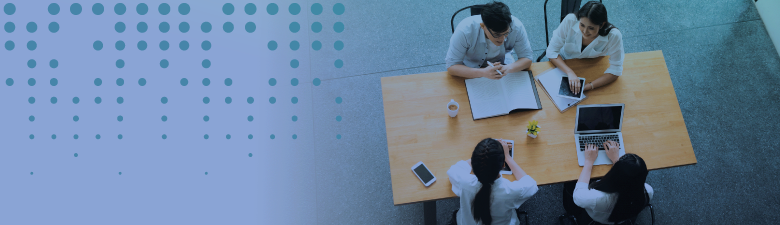 four people collaborating around a meeting table