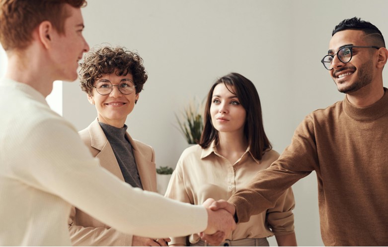 Four people in a group shaking hands