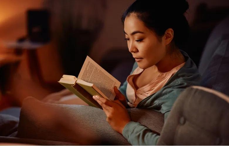 Young woman reading and enjoying a book at home