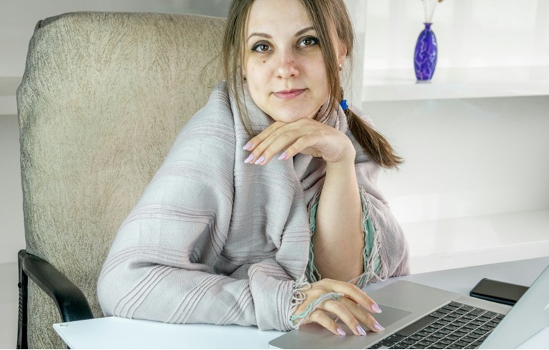 Lightly smiling woman working at laptop