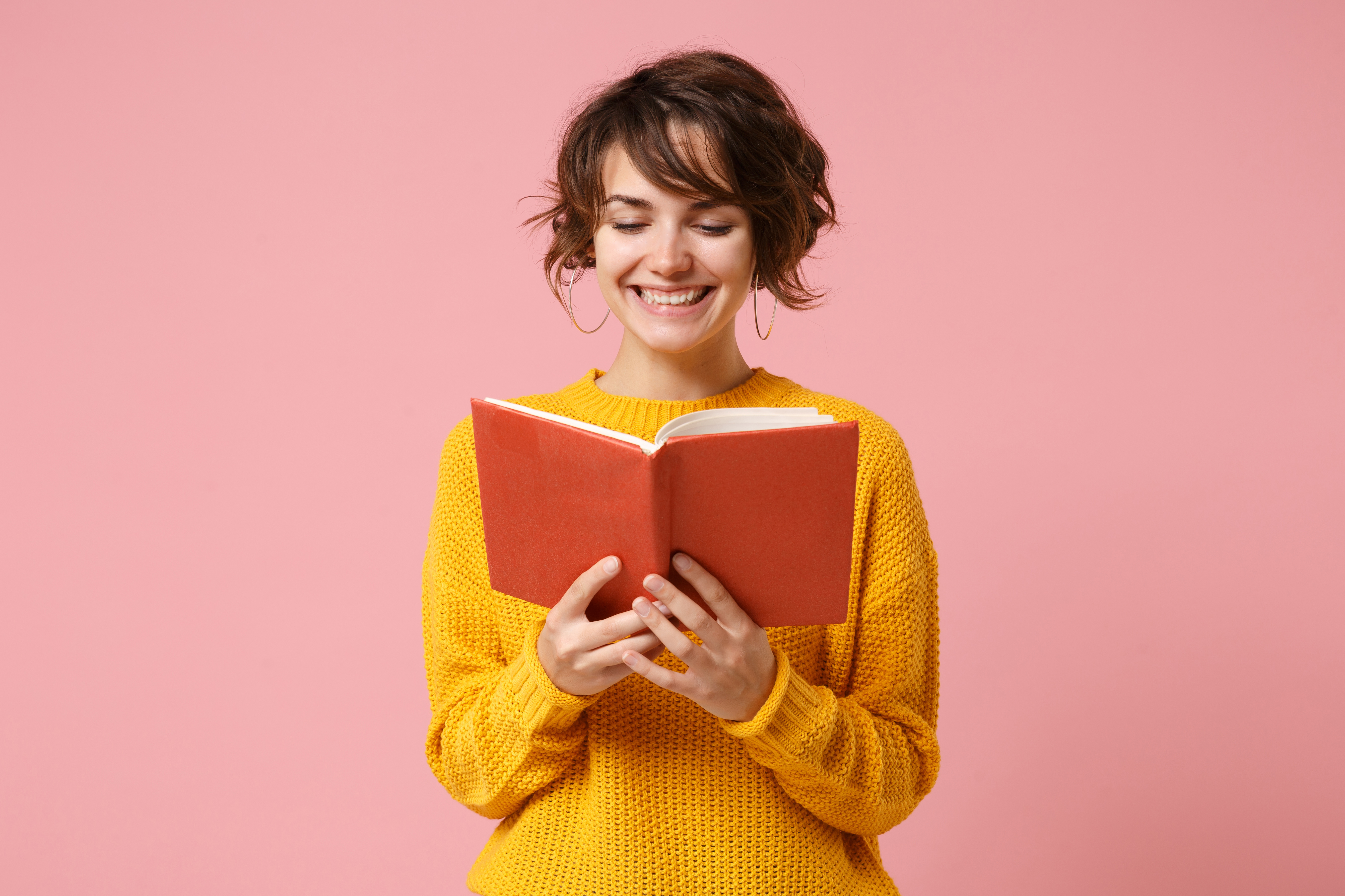 Smiling young woman reading book