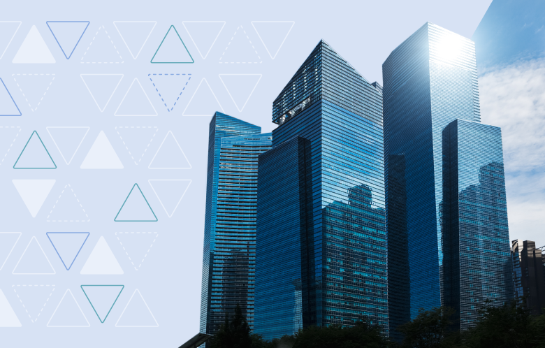 Modern glass skyscrapers against a blue sky with geometric triangle pattern