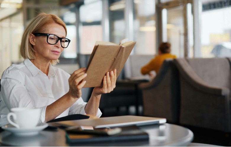 Professional woman reading book at a table