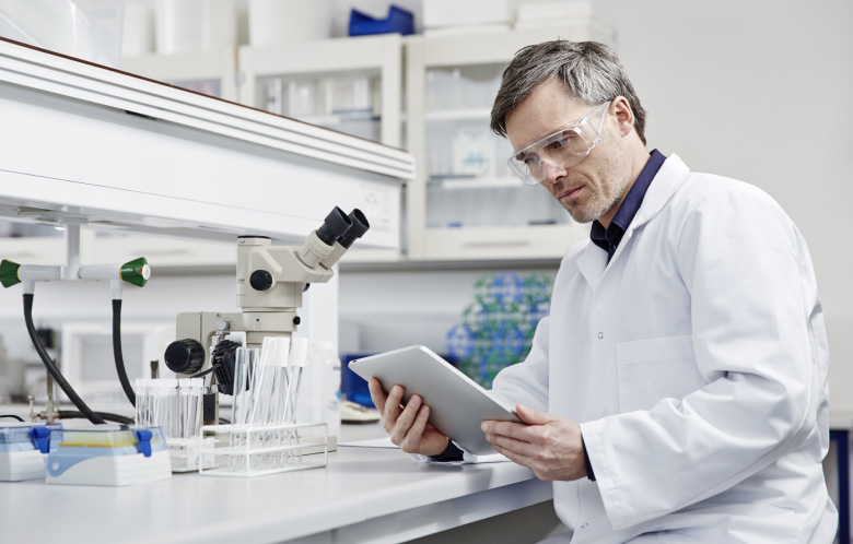 Researcher looking at tablet in lab