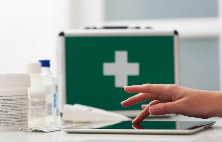 Closeup of hand on tablet and medical kit