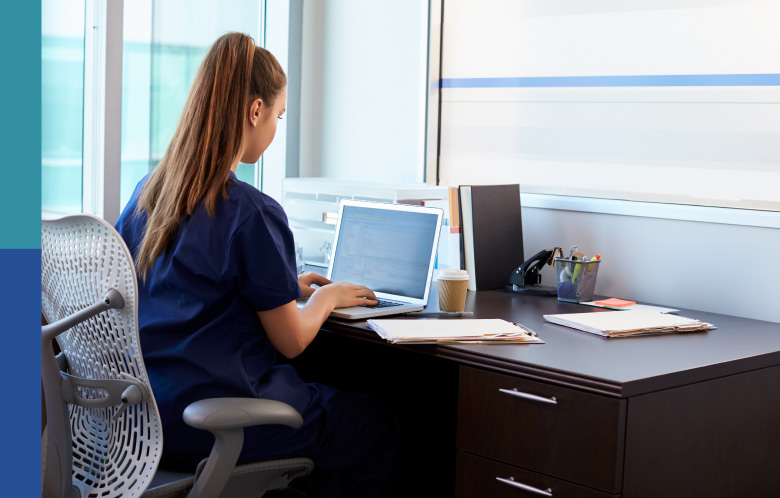 Female nurse sitting in the office researching on the computer