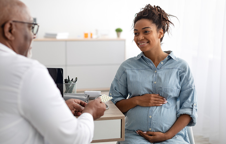 male doctor talking to pregnant woman