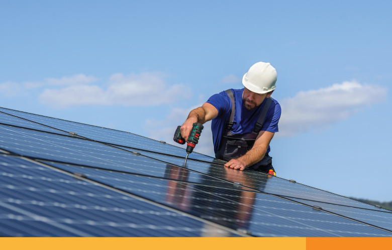 Man installing solar photovoltaic panels on roof