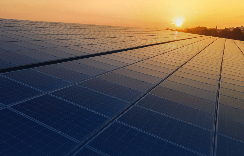solar panels with sun in the distance