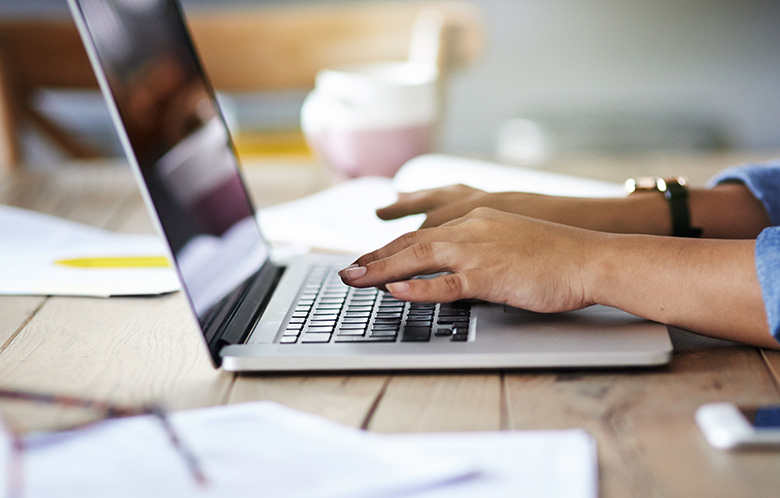 Cropped shot of a woman using a laptop while working from home