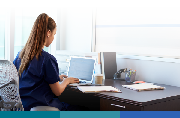 Female nurse sitting in the office researching on the computer