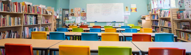 Classroom with colorful chairs and the walls lined with bookcases.