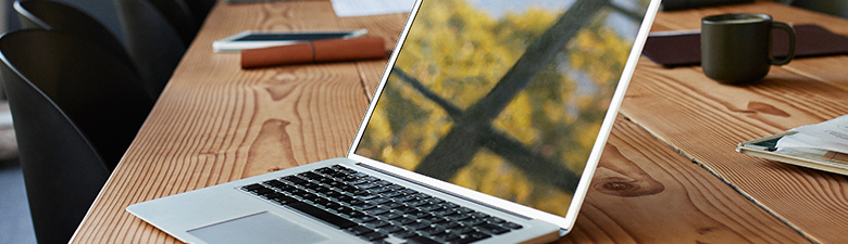 Reflection of window on laptop at conference table