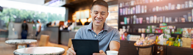 Man using digital tablet in cafe