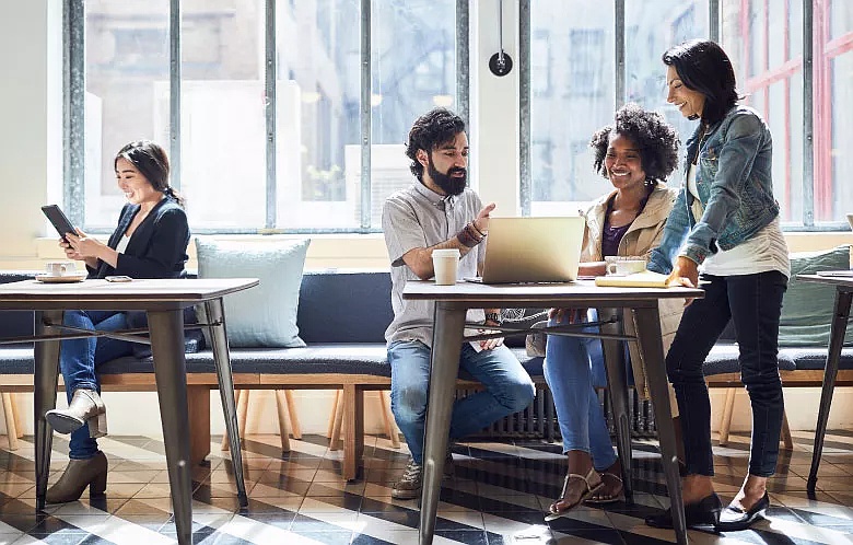 Group of people talking and researching at a tablet