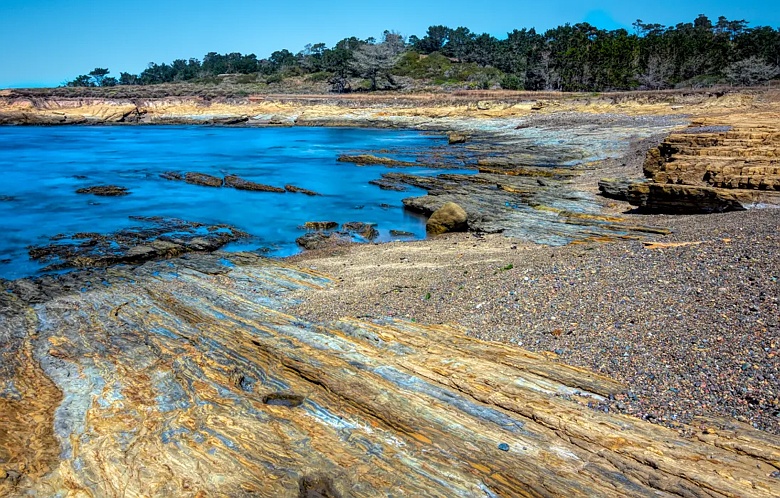 Point Lobos State Preserve ocean view featuring rocks and blue sky and ocean. In Monterey, California.