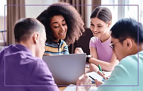 Group of students working together, looking at a laptop